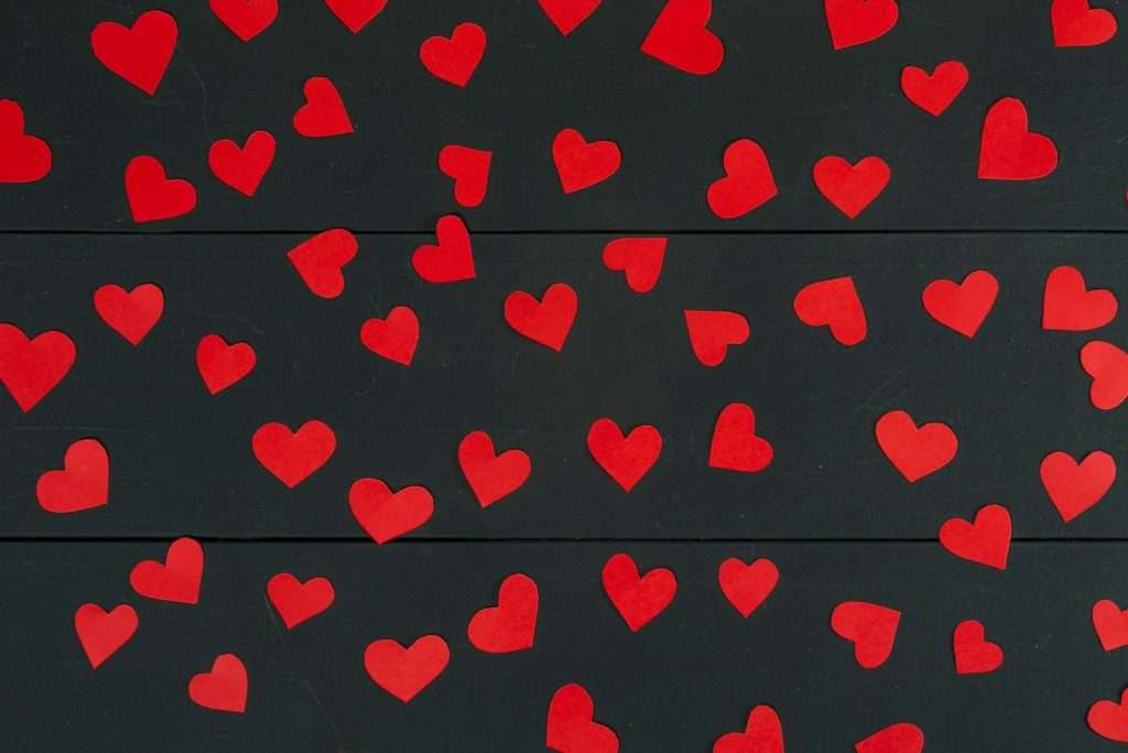 a bunch of red hearts on a black background