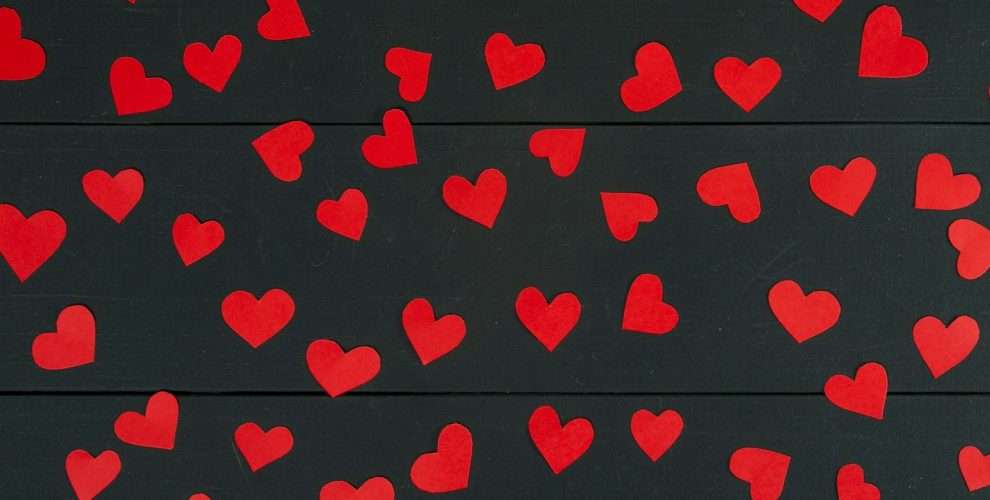 a bunch of red hearts on a black background